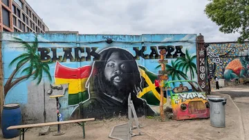 Graffiti wall featuring a portrait and flags.