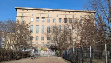 Large building with trees and graffiti.