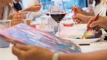People painting and drinking wine together.