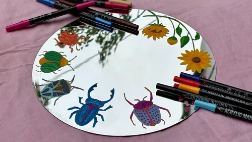 Käfer und Blumen auf Spiegel gemalt.
