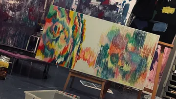 Abstract painting on easel in art studio.