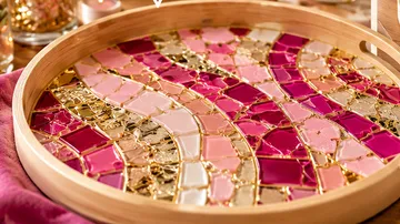 Mosaic tray workshop with tools and colorful tiles.