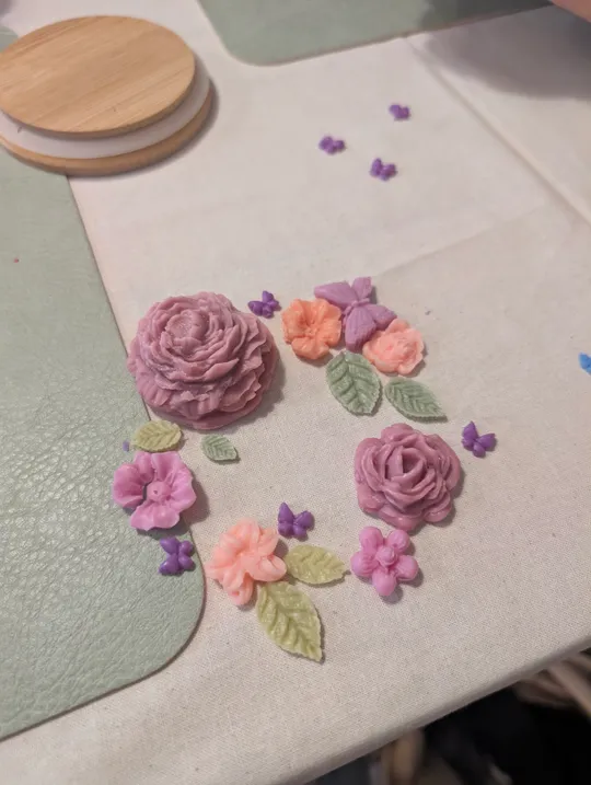 Tonblumen auf einem textilen Untergrund arrangiert.
