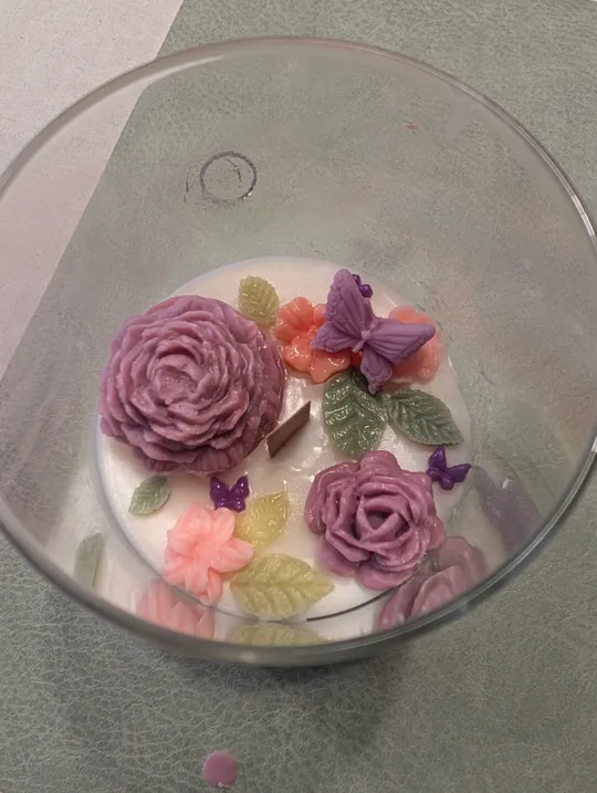 Wachsblumen und Schmetterlinge in Glasbehälter.