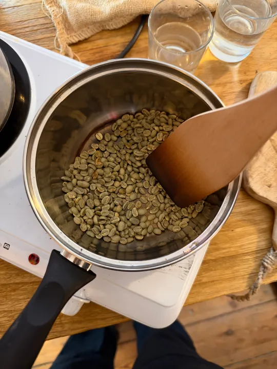 Grüne Kaffeebohnen werden auf Herd geröstet.