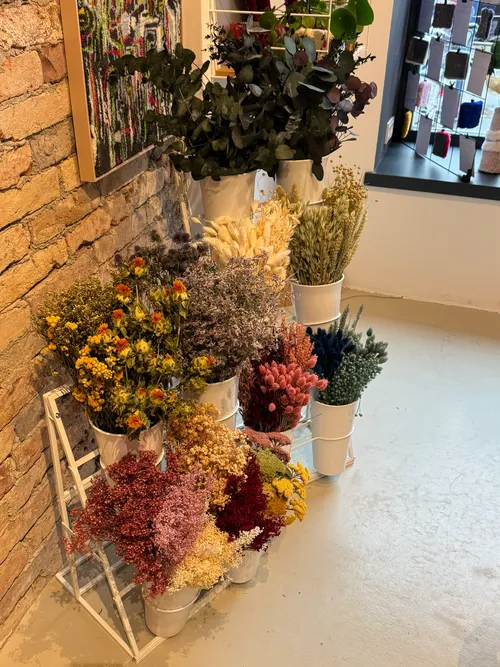 Colorful dried flowers arranged in white pots indoors.