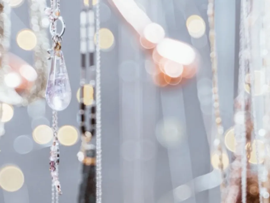 Clear crystal pendants swing against a blurred background.