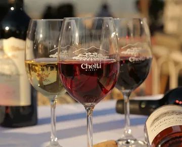 Glasses of wine on a table outdoors.