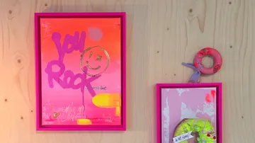 Colorful art on wooden wall, bright frames.