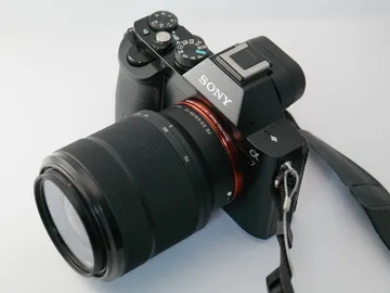 Camera takes pictures with a lens on a white background.
