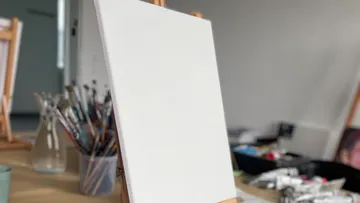 Blank canvas on easel in art studio.