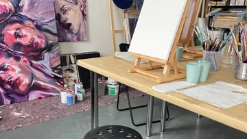 Kunststudio mit Staffeleien und ausgestellten Gemälden.