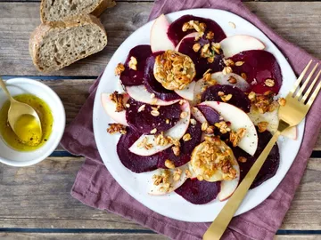 A plate with beetroot salad and apples, decorated.