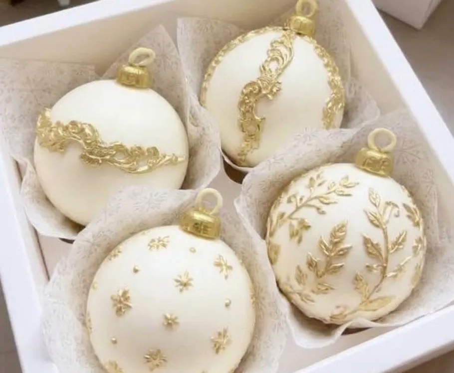 Four gold-decorated baubles in a box.