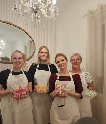Vier Frauen halten Geschenke unter dem Kronleuchter.