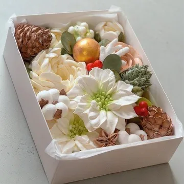 Verschiedene Blumen und Dekoration in einer Schachtel.