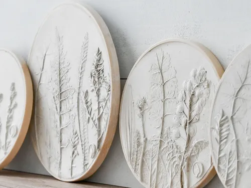 Round reliefs show plant structures hanging on a wall.