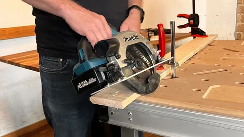 Person cutting wood with circular saw.