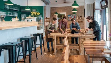 Four people woodworking in a modern studio.