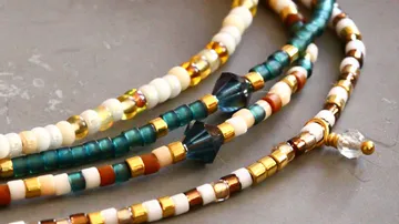 Colorful beaded necklaces laid on a surface.