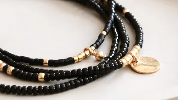 Black beaded bracelet with gold accents.