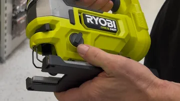 Hands adjusting a jigsaw in store.