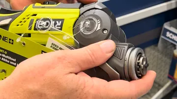 Hands holding a power tool in store.
