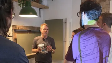 Man explaining to a group in a room.