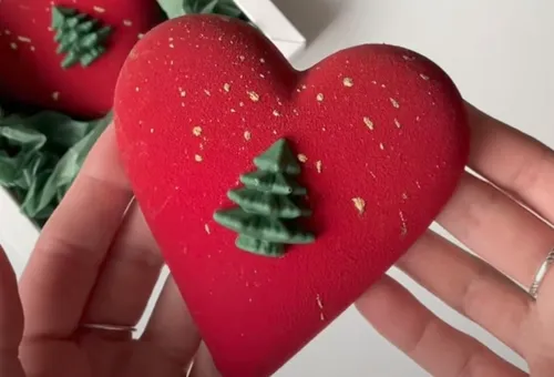 Heart-shaped dessert with Christmas tree decoration.
