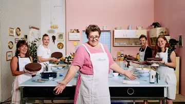 Fünf Personen backen in einer hellen Küche Torten.