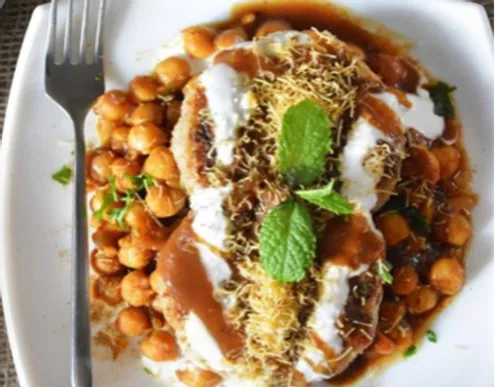 Plate with chickpeas, yoghurt, sauce and spices.
