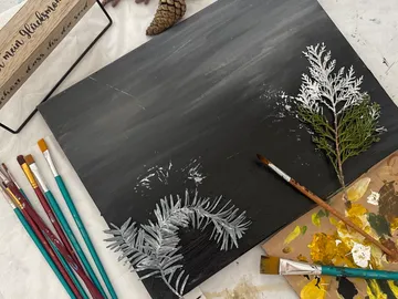Leinwand, Pinsel und Farbreste auf einem Tisch.