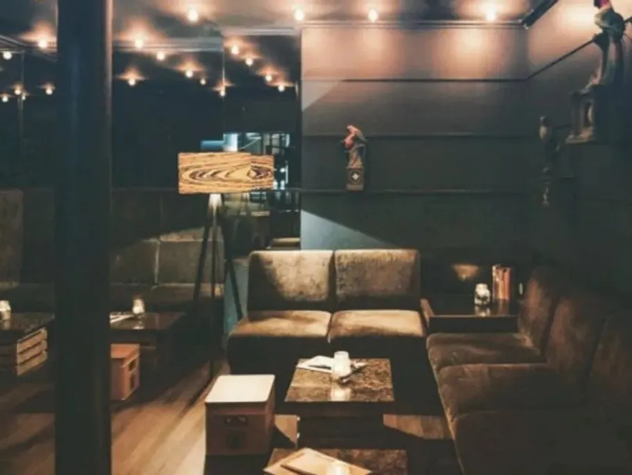 A comfortable couch is in a stylish, dimly lit room.