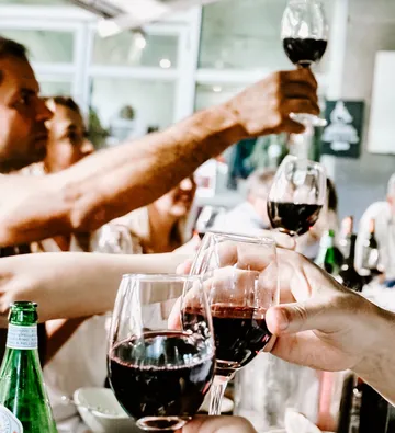 Glasses of red wine are toasted in good company.