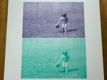 Kind mit Ball geht im Wasser, oben in Blau, unten in Grün.