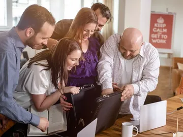 Gruppierung von Personen untersucht einen Aktenschrank in einem Büro.