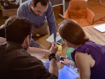 Group of people discussing documents at the table.