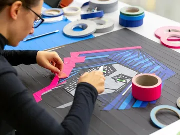 Person, die buntes Band für Kunstwerke arrangiert.