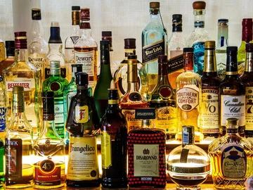 Verschiedene Flaschen Alkohol stehen nebeneinander auf einem Tisch.