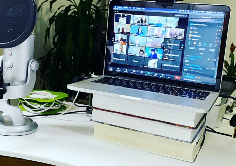 Laptop steht auf Büchern, während Videokonferenz stattfindet.