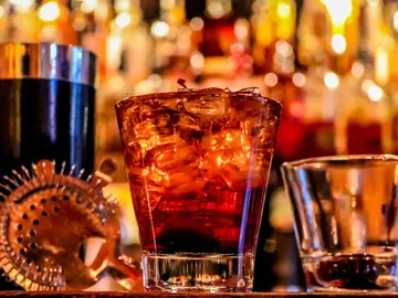 A glass of drink is on a counter.