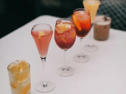 Sechs Gläser mit verschiedenen Getränken stehen auf einem Tisch.
