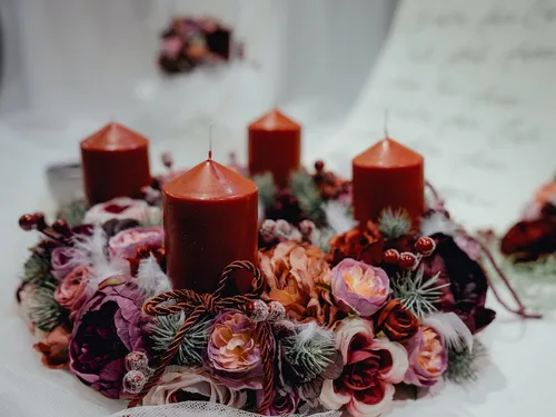 Red candles are decorated on a wreath of flowers.