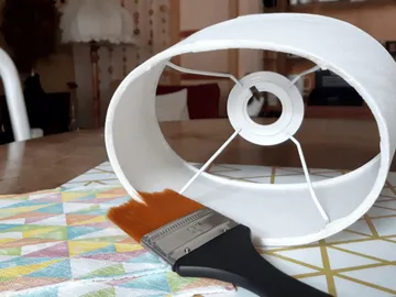 A lamp is lying on a colorful table with a brush.