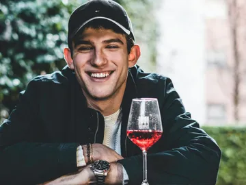 Smiling man having a drink in a garden.
