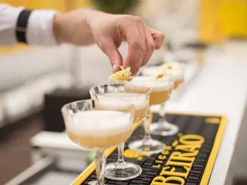 Ein Barkeeper verziert Cocktails mit essbaren Blüten.