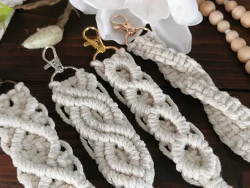 Macrame pendants lie on a wooden table.