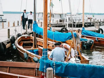 Boats are moored at the harbor, people are preparing.