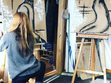 Artist draws on canvas in a studio.
