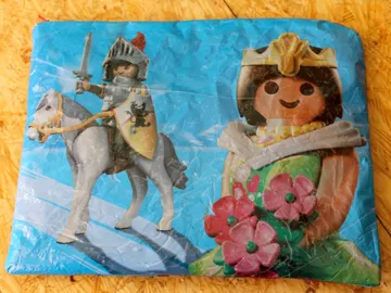 Spielzeugritter auf Pferd neben Blumenprinzessin.